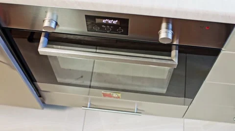Girl is putting baking pan into oven Stock Footage