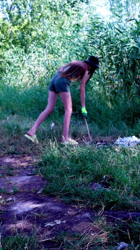 Girl putting collected litter Stock Footage 340577790