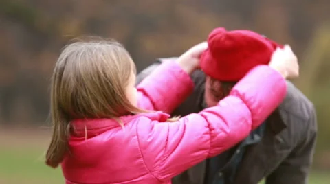 Girl putting her cap on dad's head Stock Footage 59554649