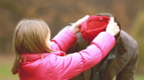 Girl putting her cap on dad's head Stock Footage 59554652