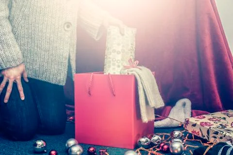 Girl putting presents in big red box, celebrating holidays Stock Photos