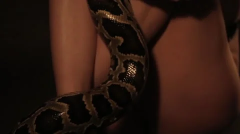 Girl with a python around his neck sitting hugging himself for knees 库存影片 68935629