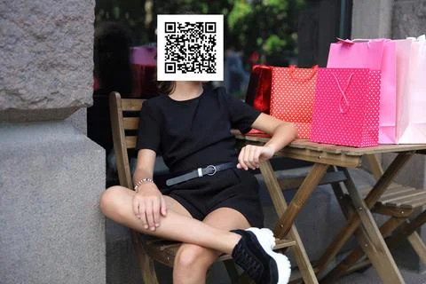 Girl with qr code on her face with shopping bags. Constraint concept Stockfoto's