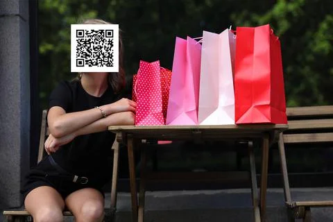 Girl with qr code on her face with shopping bags. Constraint concept Stockfoto's