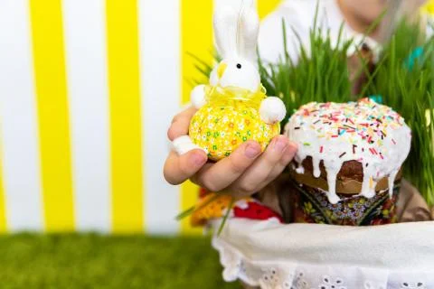 A girl with a rabbit on the backdrop of the Easter basket. Copy Space. Spring Stock Photos