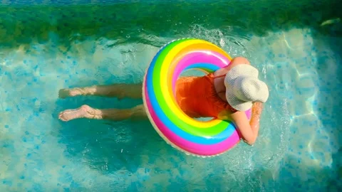 Girl with a rainbow inflatable ring in the pool.Summer time Stock Footage 180902455