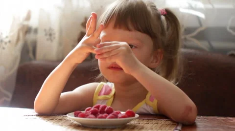 Girl with raspberries on fingers Stock Footage 50868853