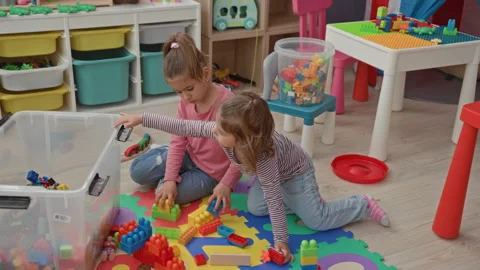 Girl reaching into a clear plastic bin to grab colorful building blocks whi.. Stock Footage 339139339