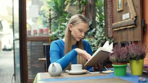 Girl reading absorbing book while sitting in the cafe Stock Footage 70447270