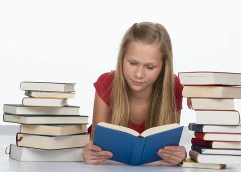 Girl reading book besides stack of books against white background 스톡 사진