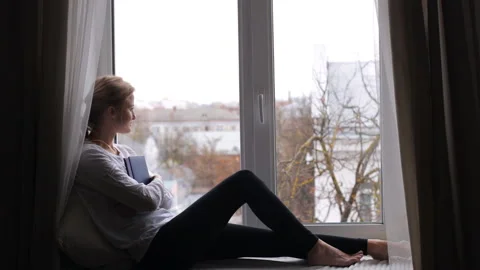 Girl is reading a book while sitting Stock Footage 99953313