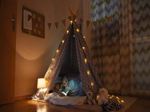 Girl reading book in wigwam in the night... | Stock Video | Pond5