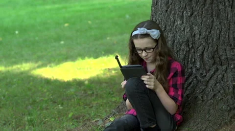 A girl reading an electronic book Stock Footage 44116334
