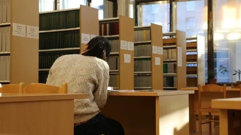 Girl reading in the library Stock Footage 103234903