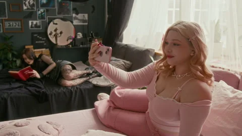 Girl Reading While Another Taking Selfie in Contrasting Gothic and Pink Room Vídeos de archivo 311995796