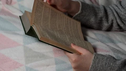 A girl reads a book while lying in bed. Stock Footage 223371953