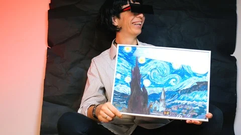 The girl in rectangular glasses holds a copy of the famous painting. 库存影片 124255396