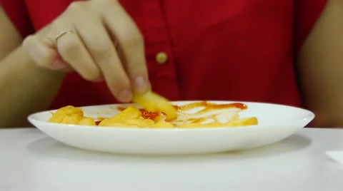 Girl in red eating fries hands, close-up Stock Footage