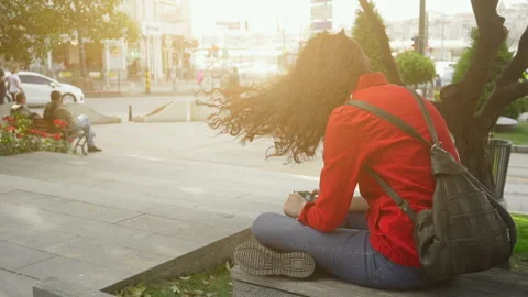 Girl in red jacket using mobile smart phone in the city park. Stock Footage 90487038