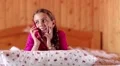Girl with red smartphone lies on the bed HD Footage