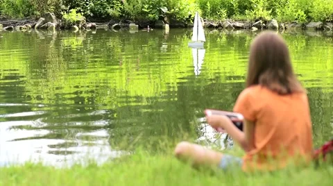 Girl with remote controlled boat Stock Footage 64828599