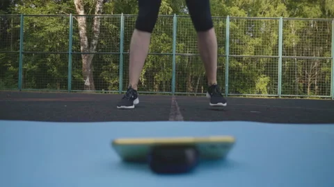 Girl repeat exercises while watching video on phone at playground Stock Footage 157210300