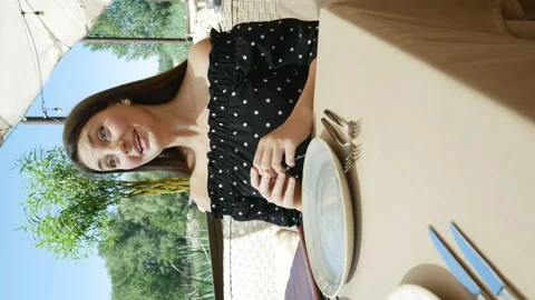 A girl in a restaurant flips through the menu.vertical video Stock Footage 137427994