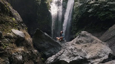 Girl resting on the background of a waterfall Stock Footage 129057041
