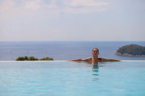 Girl resting at infinity pool Stock Photos