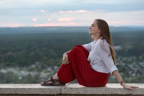 Girl is resting while sitting on observation deck. Young woman travels by her Stock-Fotos