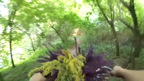 Girl rides a bicycle with a bouquet of flowers in front of the wheel Stock Footage