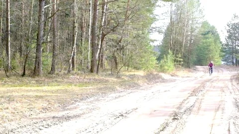 A girl riding a bicycle in the woods Stock Footage 72777042