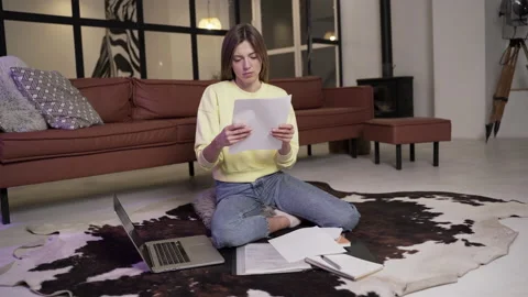 Girl rips and throws documents sitting on the floor Stock Footage 151655509