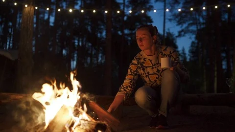 Girl roasting marshmellows at campfire at sunset Stock Footage 112110341