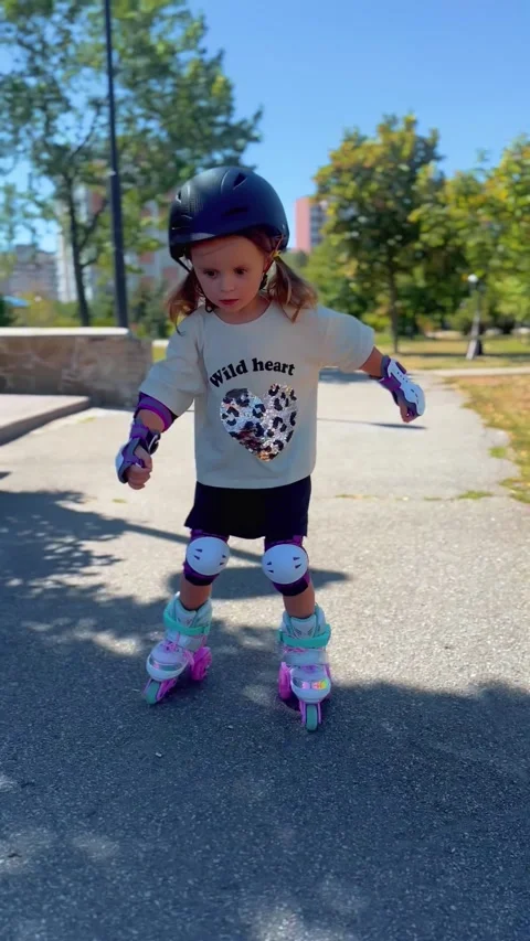 Girl roller skating along a pathway on a sunny day Stock Footage 344605672