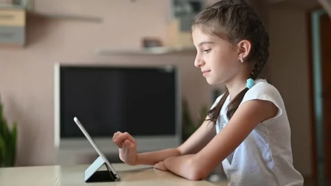 The girl in the room sits with a tablet and communicates on the Internet. Stock Footage 166320850
