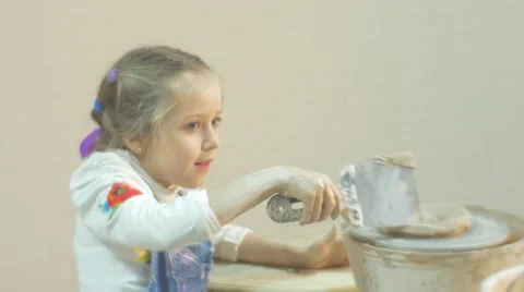Girl is Rotating a Piece of Clay on a Pottery Wheel Trying Take It Off by Stock Footage 59125438