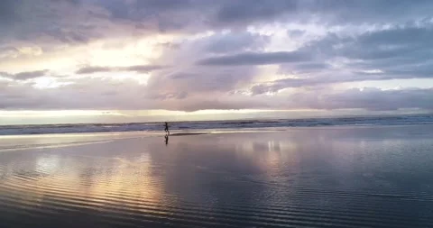 Girl running on an empty beach. Beautiful Sunrise aerial footage. Stock Footage 201059714