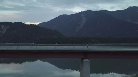 Girl is running on the empty bridge in the sunset time - Aerial Stock Footage 83753357