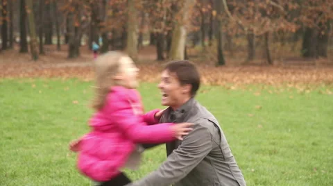 Girl running into father's arms in park Stock Footage 59554122