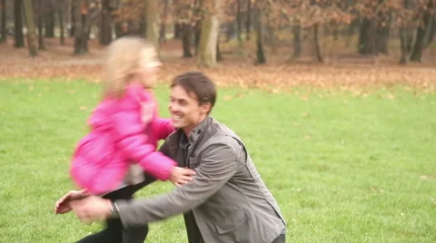 Girl running into father's arms in park Stock Footage 59554148