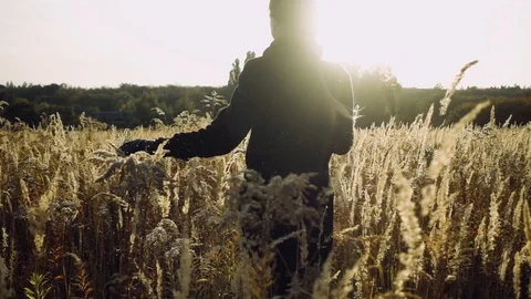 Girl running in the field with sun flares into the camera Stock Footage