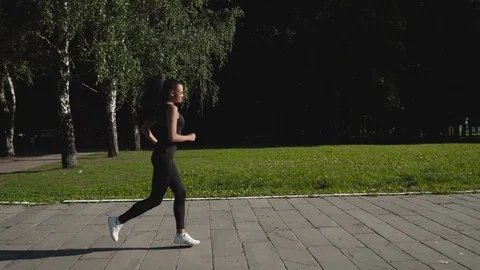 Girl running on the pier with skyline in the background, blue sky, fit sexy Stock Footage