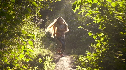Girl running through the park in the sunshine Stock Footage