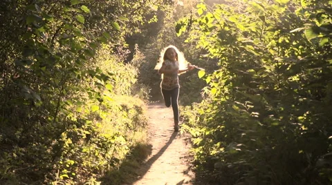 Girl running through the park in the sunshine Stock Footage
