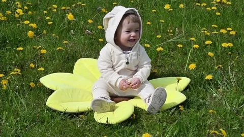 Girl runs in a dandelion field, the first steps of the child Stock Footage 108421653