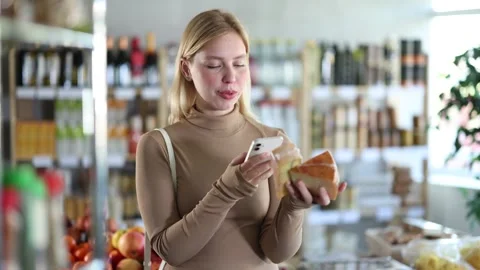 Girl scan QR code, take reading cheese label using phone camera in shop Stock Footage 307063515