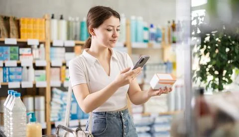 Girl scans code on package of pills to check the expiration date Фото