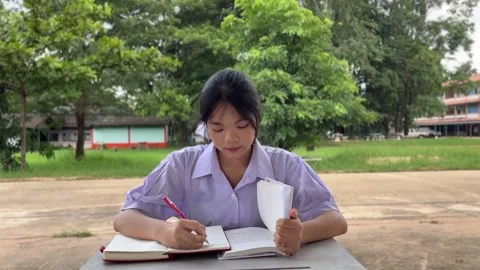 A girl in a school uniform taking notes Stock Footage 318860993