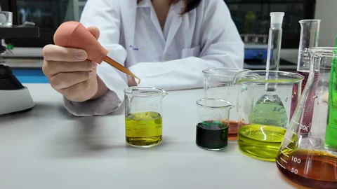 Girl scientist loads liquid sample into beaker Stock Footage 276700005